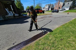 A residential driveway being sealcoated by a Superior Sealcoating employee - Superior Sealcoating in Glen Mills, PA - Superior Sealcoating