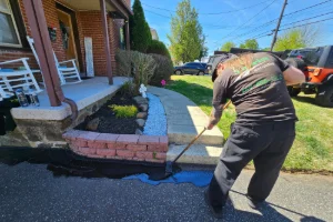 A residential driveway being sealcoated by a Superior Sealcoating employee - Superior Sealcoating in Glenmoore, PA - Superior Sealcoating