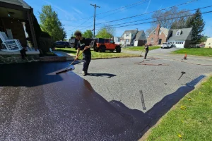 A residential driveway being sealcoated by a Superior Sealcoating employee - Superior Sealcoating in Honey Brook, PA - Superior Sealcoating