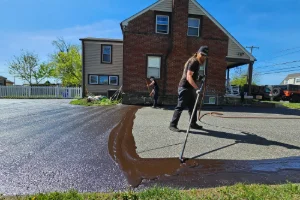 A residential driveway being sealcoated by a Superior Sealcoating employee - Superior Sealcoating in Phoenixville, PA - Superior Sealcoating