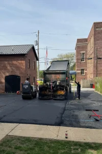 Image of a truck dumping asphalt onto a residential driveway