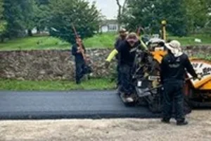 A residential driveway in the process of being paved by a Superior Sealcoating employee - Paving in Malvern, PA - Superior Sealcoating