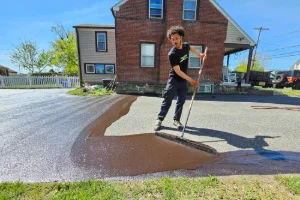 Image of a worker sealcoating a residential driveway